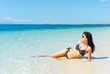 © upslim - Young happy woman in black bikini enjoys sunny day on beach. Tropical vacation