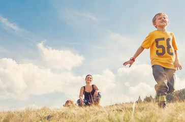 Mother son and dog on the golden field