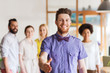 © Syda Productions - happy man making handshake over office team