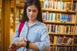 © WavebreakmediaMicro - Brunette student using her smart watch
