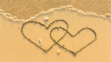 Two Hearts Drawn On The Sand Beach With The Soft Wave. Honeymoon Concept.