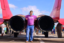 Man Stands Near Nozzle Of Military Aircraft On Land 