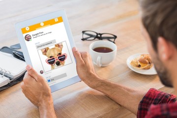 Sticker - Composite image of rear view of man using tablet on wooden table