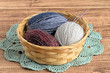 © elizaveta66 - Yarn.  Balls of colored wool yarn in a basket on a brown wooden background. 