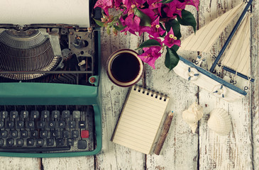 Wall Mural - image of vintage typewriter, blank notebook, cup of coffee and old sailboat on wooden table