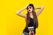 Close up fashion lifestyle portrait young hipster girl, wearing bright make up and sunglasses, making sexy faces. Urban yellow wall background.