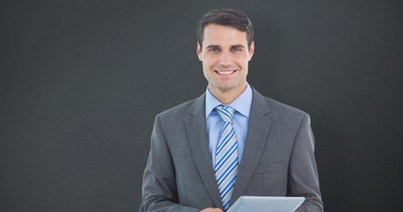 Wall Mural - Composite image of businessman using a tablet 