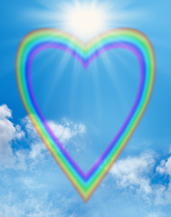 Wall Mural - Rainbow love heart blue sky frame - a large empty rainbow shaped heart creating a frame on a blue sky background with a big bright sunburst positioned in the cleavage of the heart