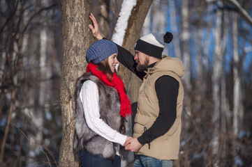 Young couple out for a walk, sunny winter day. Bearded man and woman on romantic weekend.Couple holding each other's hands.