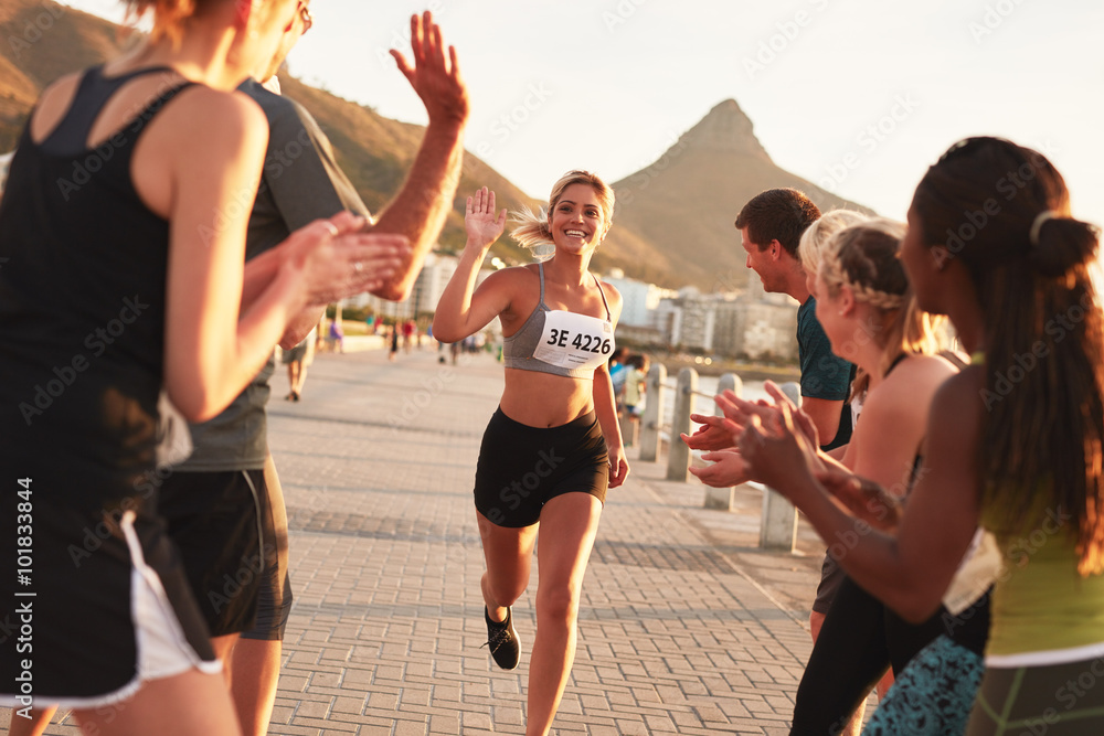 Group of spectators cheering runners at finish line Stock Photo | Adobe ...