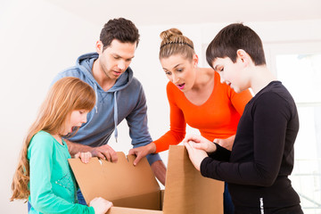 Wall Mural - Familie packt Umzugskisten aus in neuer Wohnung