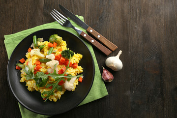 Sticker - Black plate with vegetable risotto on served wooden table