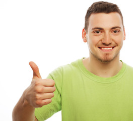 Wall Mural - young man in green shirt  showing thumbs up. 