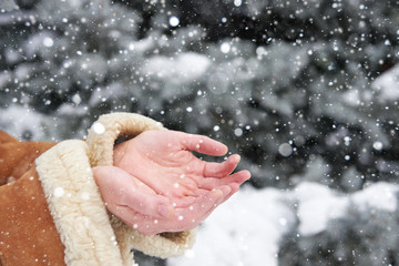 Snow falls on women's hands, winter season