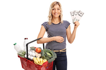 Canvas Print - Woman holding a shopping basket and money