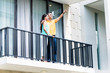 Indian woman and man standing on balcony of house