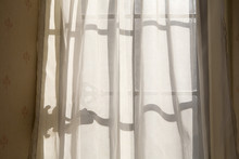 Window Shadows. Sunshine Makes Interesting Shadows On The Net Curtains That Are Part Of Dated Decorations Of A Retro Interior.