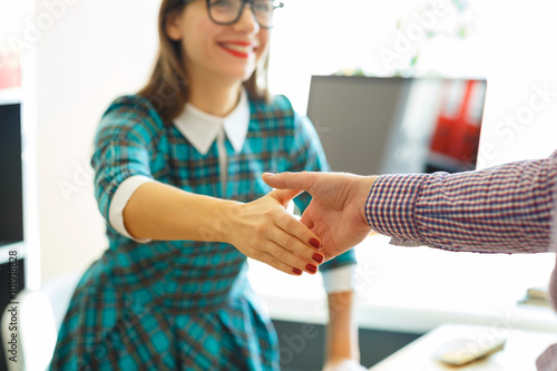 Fotografie, Obraz Pretty young business woman with arm extended to handshake