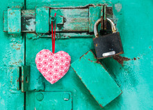 Red Heart Is Hanging On A Door With Lock