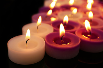 Wall Mural - Many burning small candles on dark background, close-up