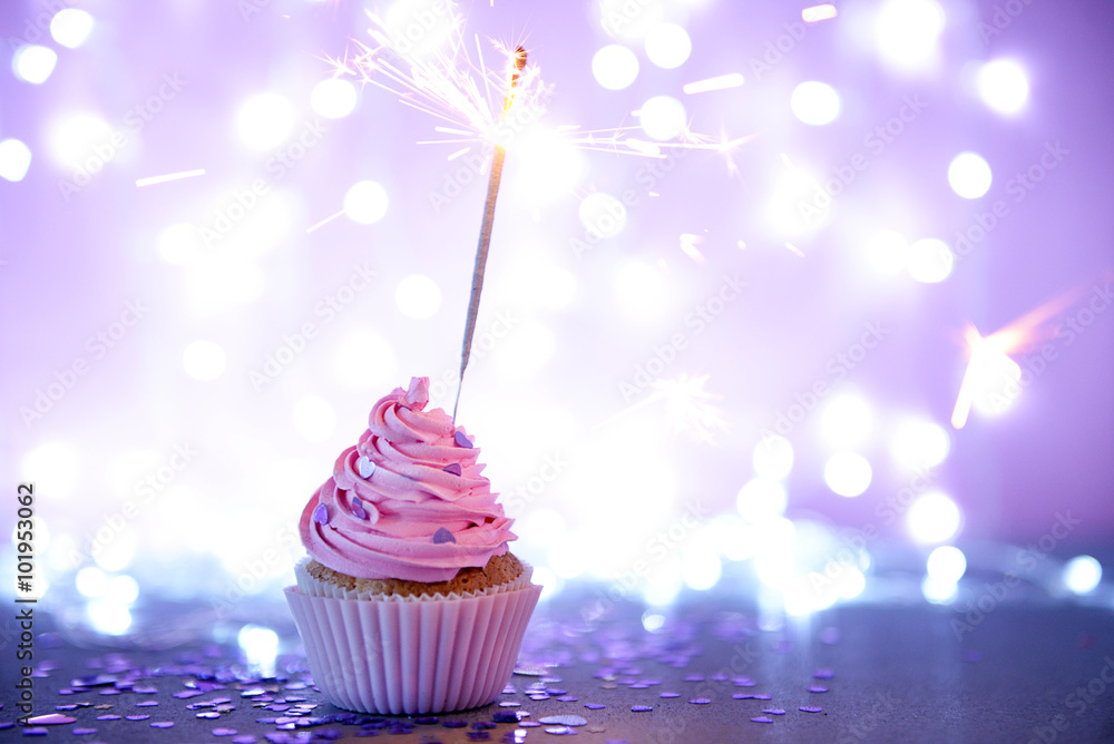 Cupcake with pink cream icing and sparkle on a glitter background
