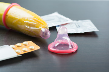 Condom with banana and contraception on wood background. Save Se