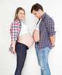 portrait of pregnant woman and husband touching with big tummies