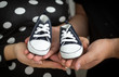 Closeup of expectant parents holding baby boots on hands