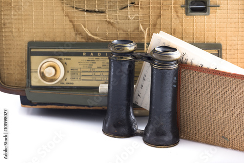 Poster some vintage and antique objects including a radio, binoculars and an old letter