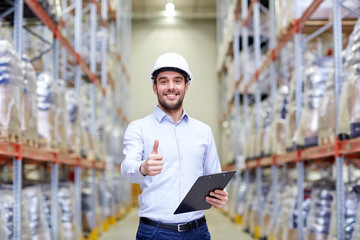 Wall Mural - happy man at warehouse showing thumbs up gesture