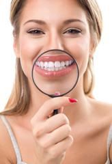 Wall Mural - woman with magnifying showing her perfect teeth