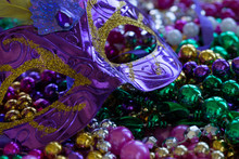 Closeup On Mardi Gras Beads With Purple Eye Mask