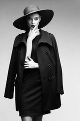 Wall Mural - high fashion portrait of elegant woman in black  hat and coat.