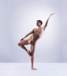 © Acronym - Athletic ballet dancer in a perfect shape performing over the grey background.
