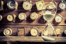 Vintage Hourglass On The Background Of Clocks