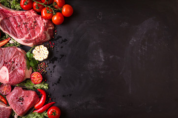 Canvas Print - Raw meat steaks on a dark background ready to roasting