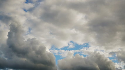 Wall Mural - thick, puffy cumulus clouds roll over a blue sky in time lapse fashion. 60 second loop.