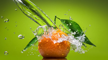 Wall Mural - tangerine with green leaves and water splash on green