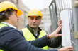 © cineberg - Architect and engineer holding technical drawings at construction site