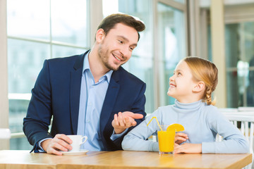 Young father having a conversation with curious daughter.