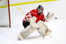 Hockey Goalie In Generic Red Equipment Protects Gate