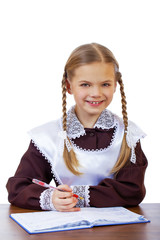 Wall Mural - Young beautiful schoolgirl sitting at a desk