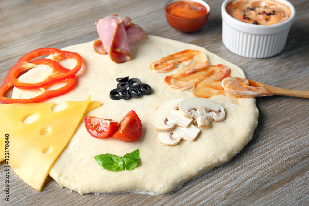Fresh ingredients for pizza preparing on wooden table, close up