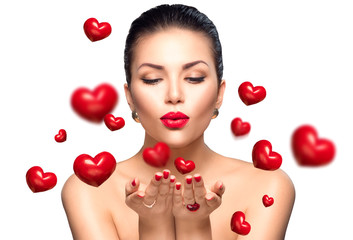 Wall Mural - beauty woman with perfect makeup blowing valentine hearts