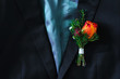 Red rose boutonniere on suit of the groom