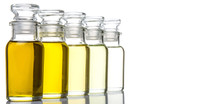 Avocado Fruit Oil, Sesame Seed Oil, Olive Oil, Grape Seed Oil And Corn Oil In Vial Glass Bottle Over White Background