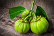 Still life with fresh garcinia cambogia on wooden background 