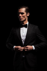 Sticker - elegant businessman posing in dark studio looking away