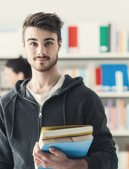 Wall Mural - Confident student posing in the library