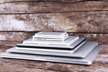 Poster - Pile of different modern electronics gadgets on old wooden background